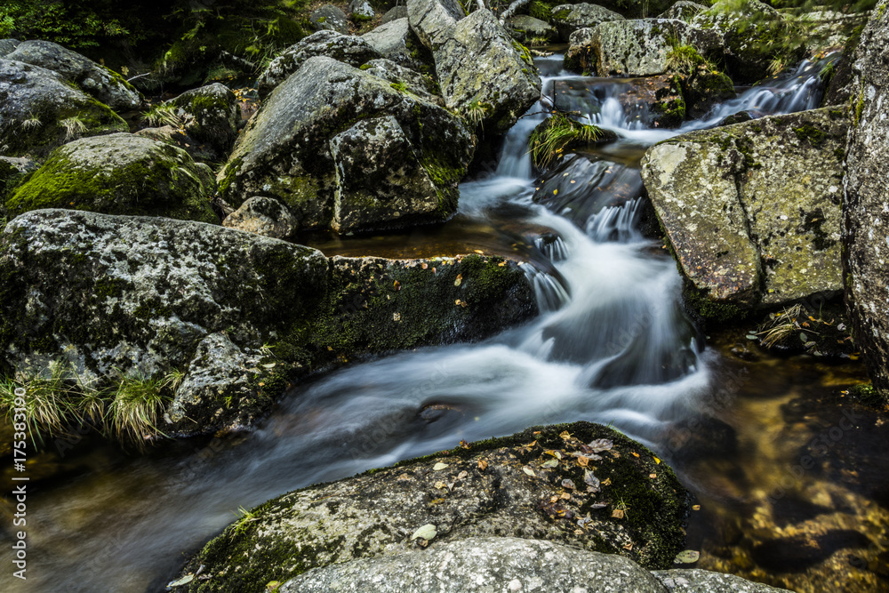 Waterfall falling on stones through autumn forest. Fall nature specification. Waterfall falling on stones through autumn forest. Fall nature specification.