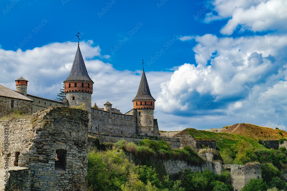 Old Kamianets-Podilskyi Castle under a cloudy blue sky. The fortress located among the picturesque nature in the historic city of Kamianets-Podilskyi, Ukraine