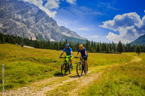 Mountain biking couple with bikes on track, Cortina d'Ampezzo, Dolomites, Italy