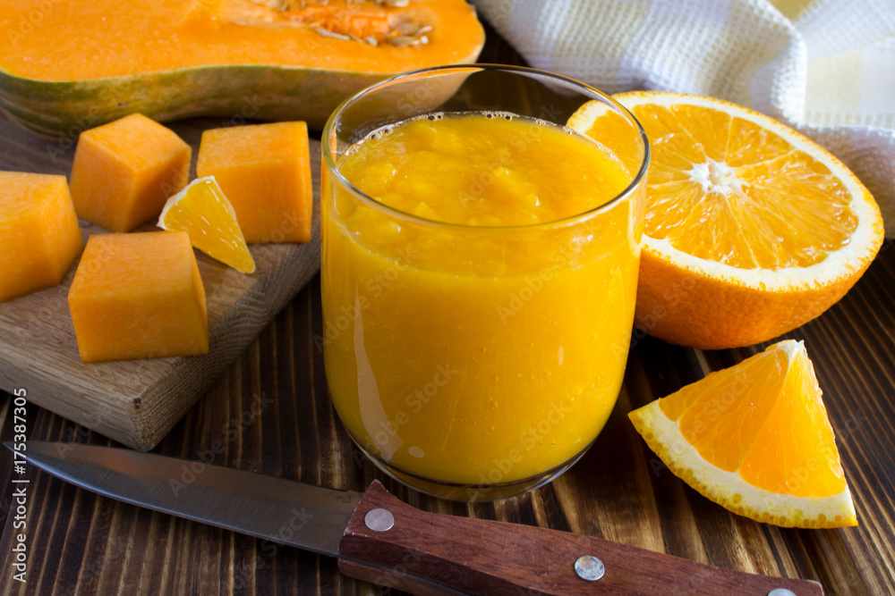 Smoothie with pumpkin, orange and ingredients on the wooden background Smoothie with pumpkin, orange and ingredients on the wooden background