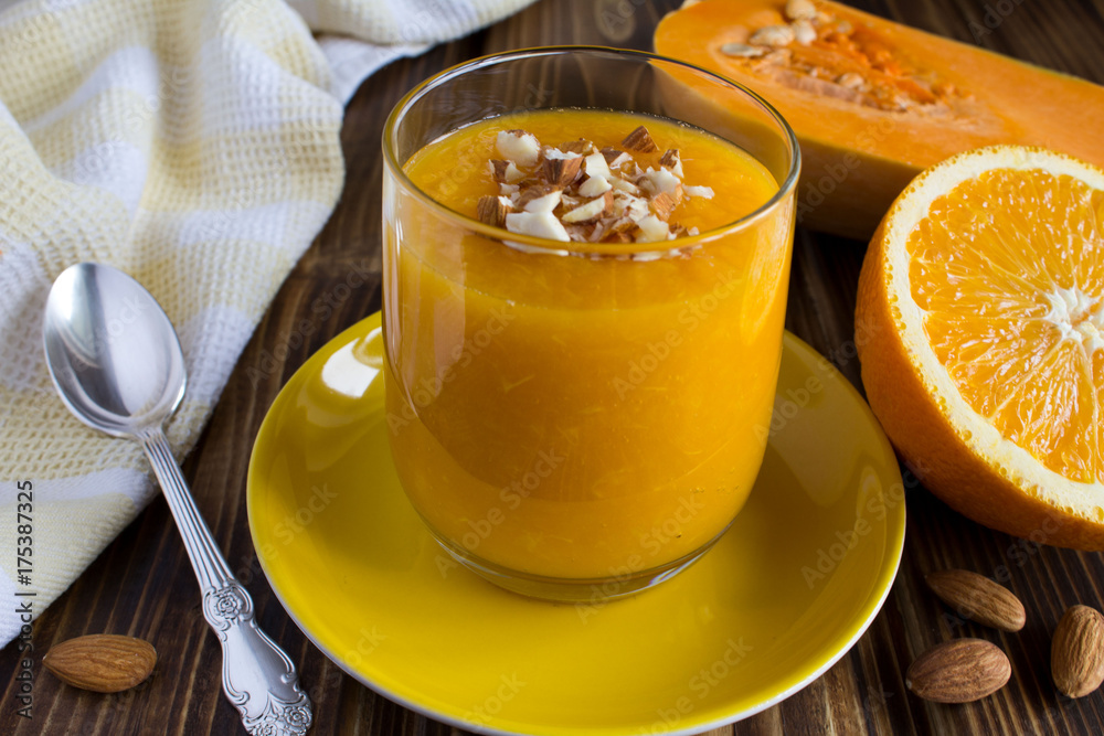 Breakfast: smoothie with pumpkin, orange and almond on the wooden background Breakfast: smoothie with pumpkin, orange and almond on the wooden background