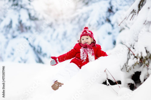Child playing with snow in winter.Boy in snowy park.
