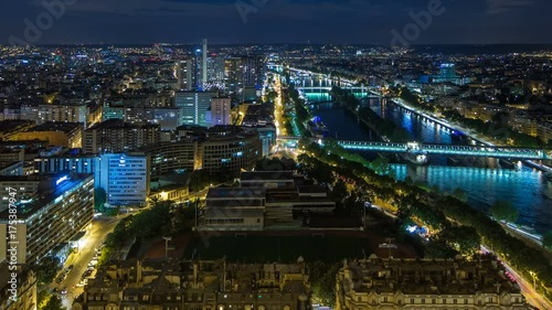 Aerial Night timelapse view of Paris City and Seine river shot on the top of Eiffel Tower photo