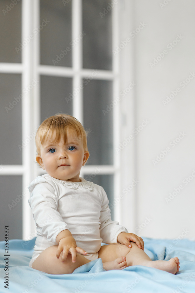 Smiling baby girl sit on the bed Smiling baby girl sit on the bed