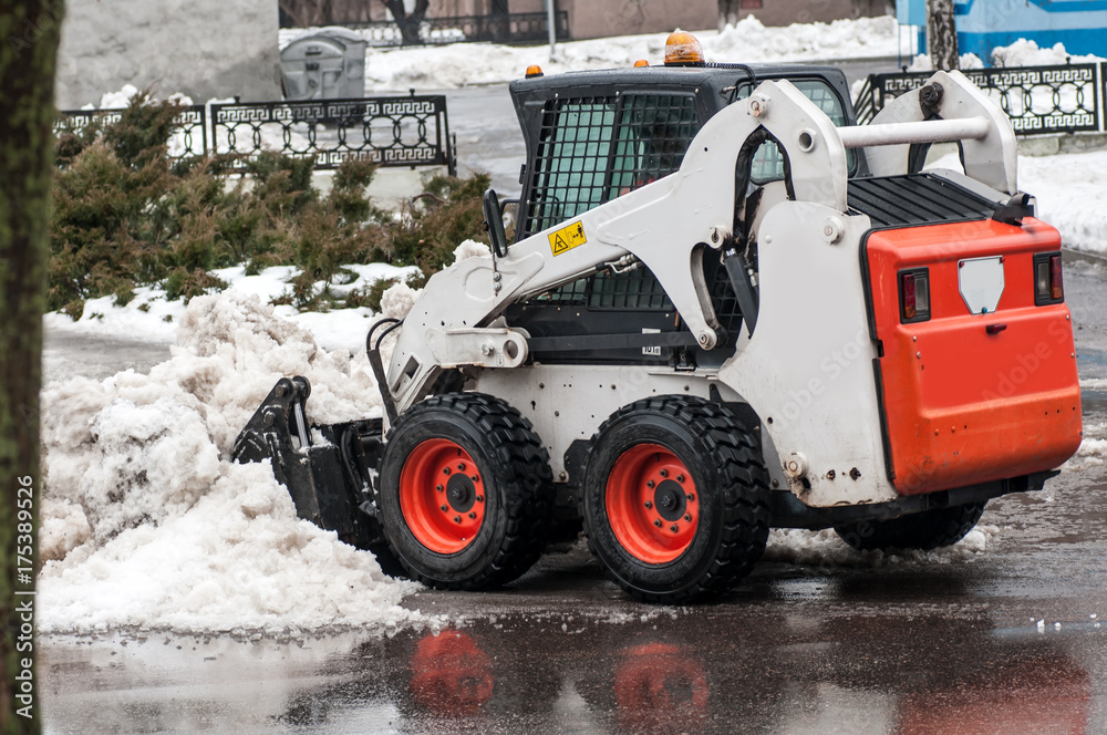 snow cleaning machine on the streets of the city in winter snow cleaning machine on the streets of the city in winter