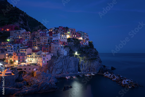 Stunning view of the beautiful and cozy village of Manarola in the Cinque Terre National Park at night. Liguria, Italy. © djevelekova