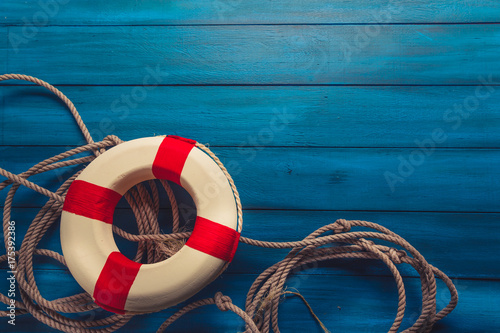 фотографія life saver with rope on a blue wooden background
