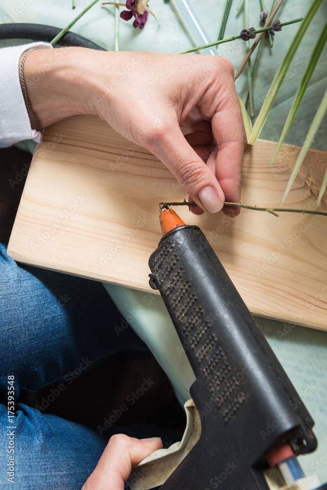 Woman hands applying glue during flower composition making Woman hands applying glue during flower composition making