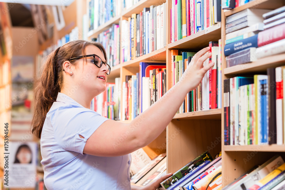 Woman in bookstore or library looking for book Woman in bookstore or library looking for book