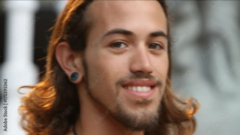 Long haired man turns and smiles, close up Long haired man turns and smiles, close up
