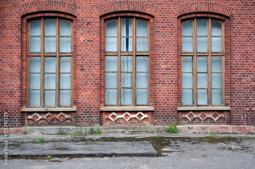 Three antique windows in the wall of red brick