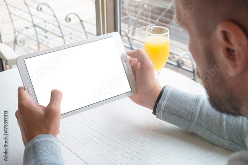Tablet mockup. Guy hold tablet in horizontal position. App or responsive web site design promotion.