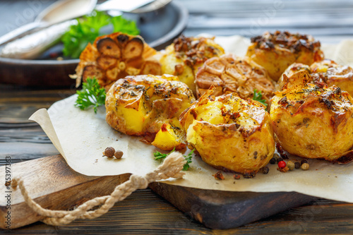 Baked potatoes in skin with spices, olive oil and garlic. © sriba3