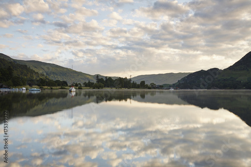 Reflections on the surface of Ullswater lake at sunrise. Cumbria, UK.