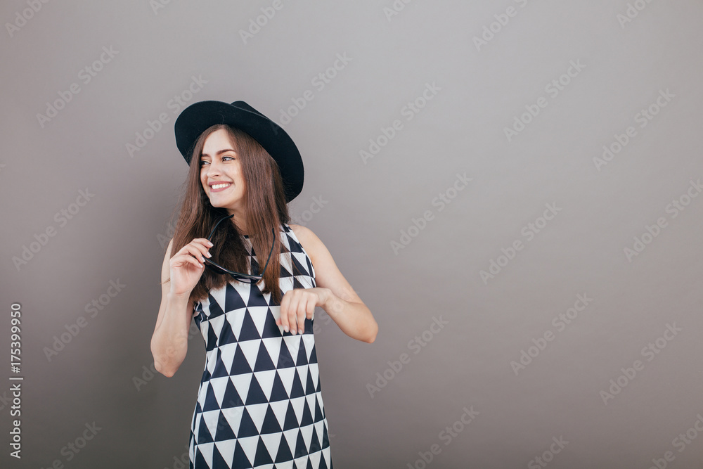 Young beautiful fashionable woman with trendy makeup in black hat and glasses on the grey background . Model looking at camera, wearing stylish eyeglasses. Female fashion, beauty concept.
Young beautiful fashionable woman with trendy makeup in black hat and glasses on the grey background . Model looking at camera, wearing stylish eyeglasses. Female fashion, beauty concept.