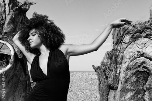 Ragazza con paesaggio marino e albero spoglio photo