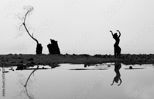Ragazza con paesaggio marino e albero spoglio