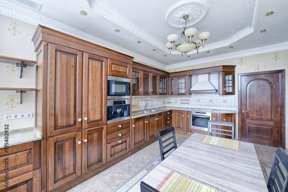 The kitchen is solid wood in a classic style in a modern house.
The kitchen is solid wood in a classic style in a modern house.