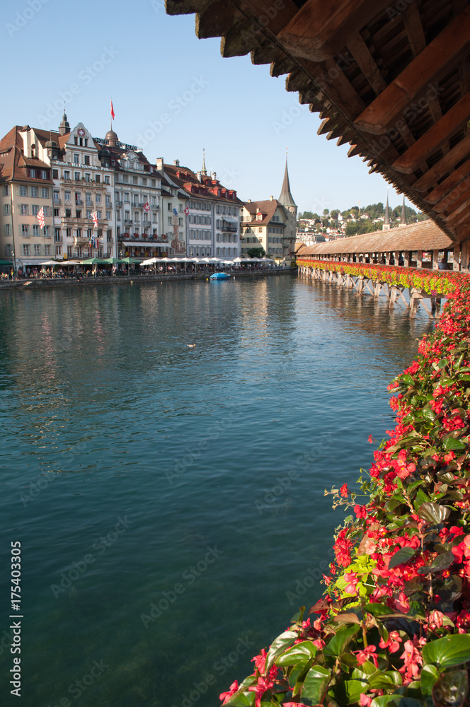 Lucerne, Switzerland - old wooden bridge over the river decorated with flowers	
