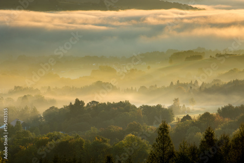 Unusual view of the autumn fog in the mountains at dawn.