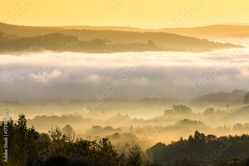 Unusual view of the autumn fog in the mountains at dawn.