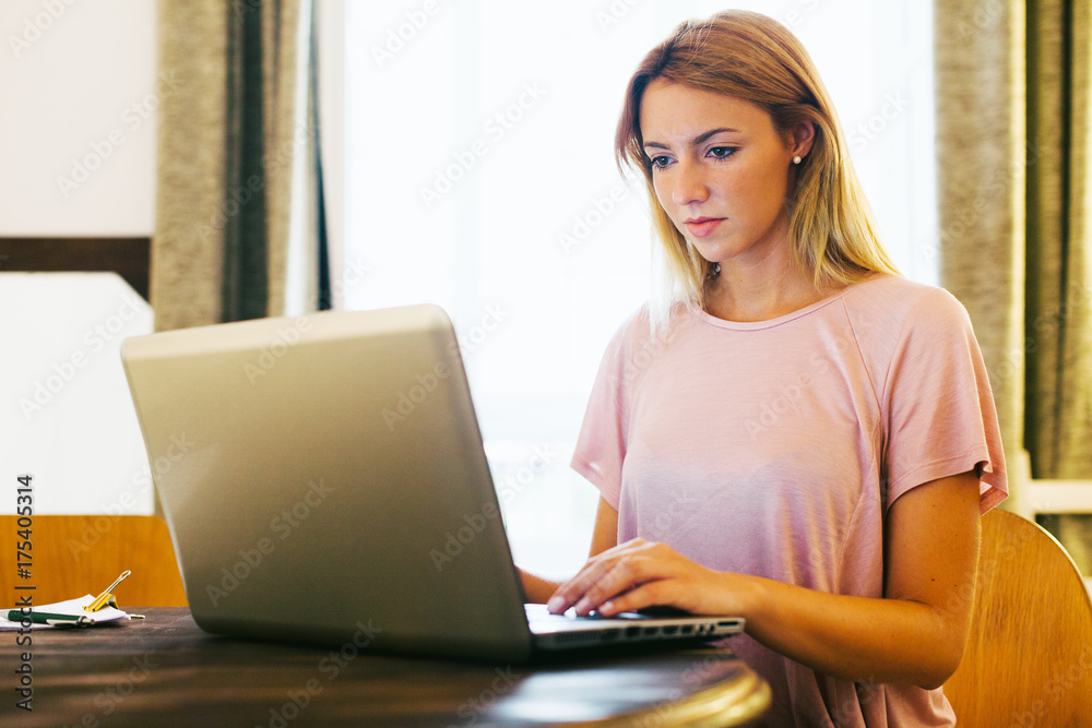 Young businesswoman working with her laptop sitting at office. Young businesswoman working with her laptop sitting at office.