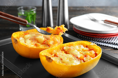 Fork with baked flesh and halves of stuffed spaghetti squash on baking sheet photo