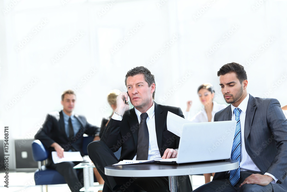 serious businessman talking on mobile phone sitting at your Desk serious businessman talking on mobile phone sitting at your Desk