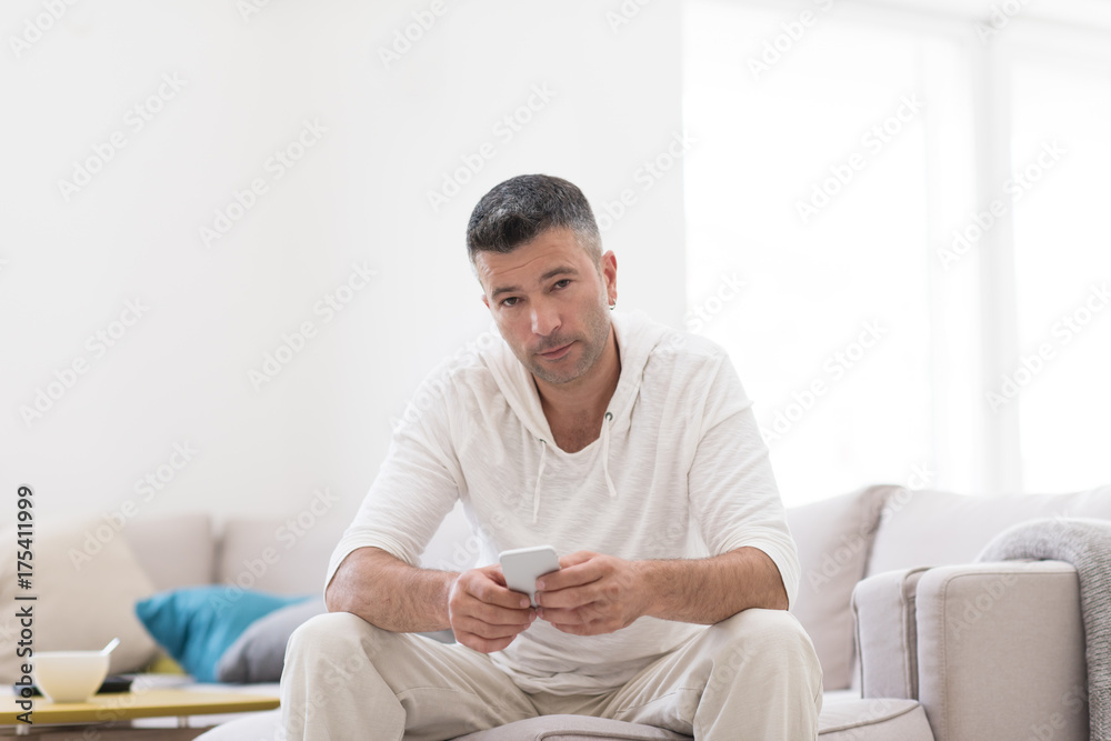 young man using a mobile phone at home young man using a mobile phone at home