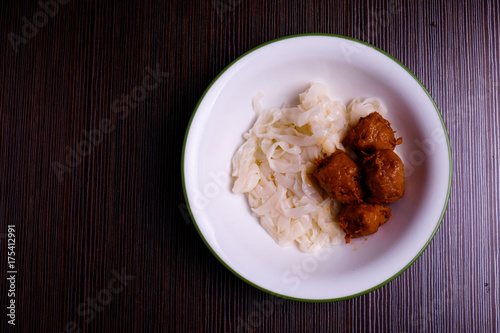 Kuey teow and meatballs in a white bowl on the table