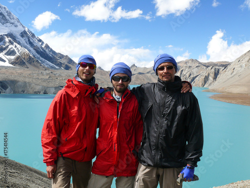 Happy hikers and the Tilicho lake, the highest lake for its size in the world