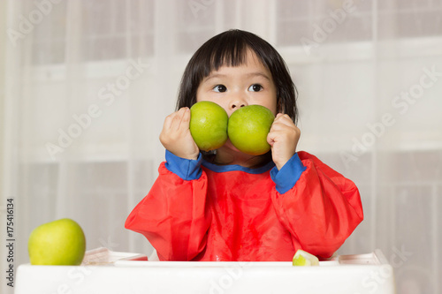 Cute happy beautiful smiling playful chid girl Asia eating  an