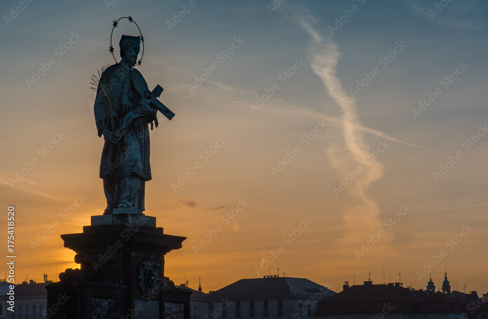 Sculpture on Charles bridge with sunrise in background