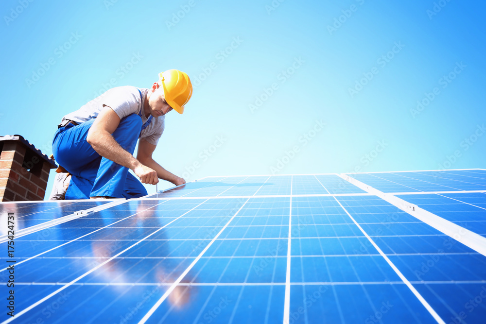 Worker installing solar panels outdoors - obrazy, fototapety, plakaty 