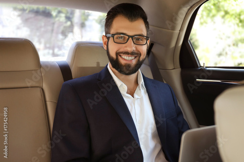 Businessman in elegant suit on backseat of car © Africa Studio