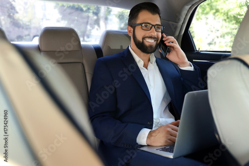 Businessman in elegant suit on backseat of car © Africa Studio
