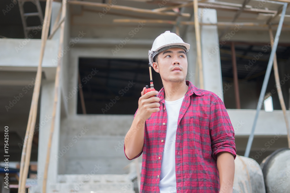 Engineer builder in hardhat using mobile phone and walkie talkie or ...