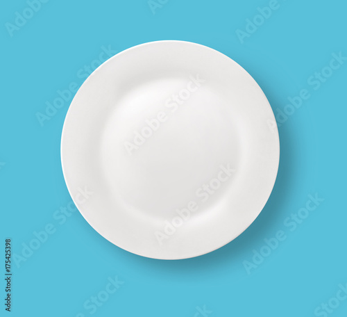 Blank white dinner plate on blue background.