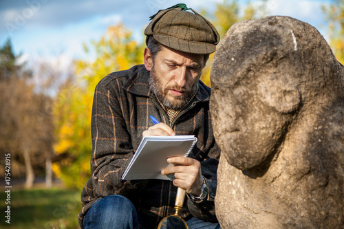 Canvas Print scientist and historian, describes sitting stone sculpture on mound