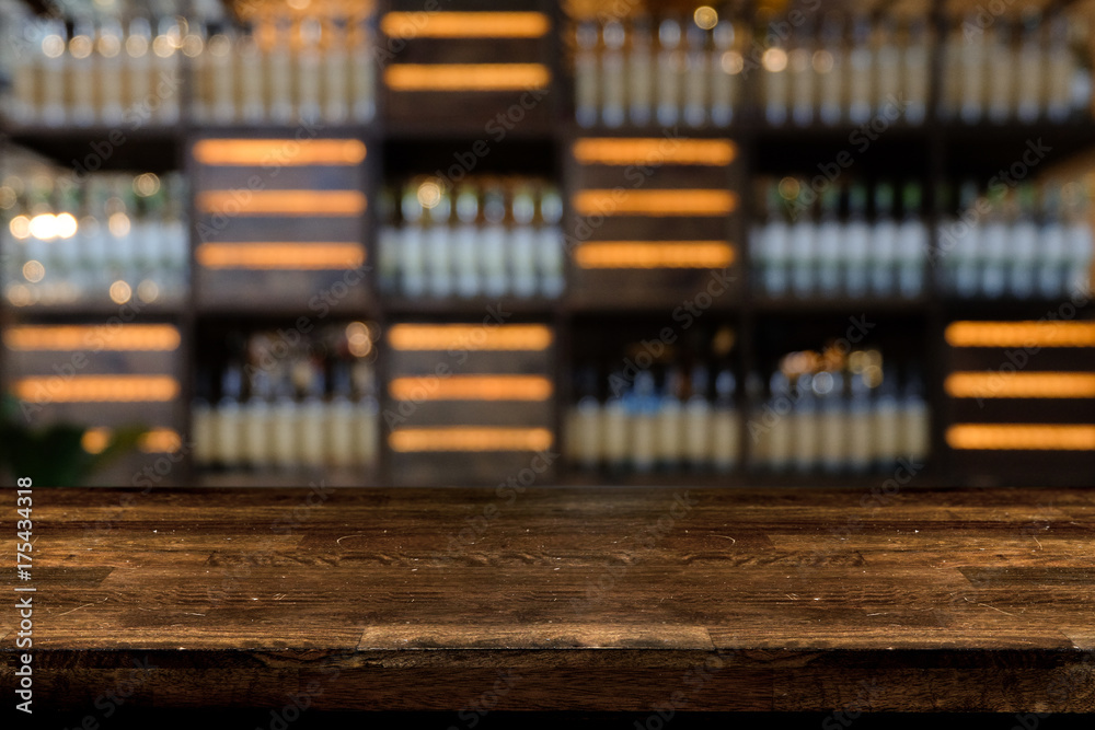 Empty the top of wooden table with blurred counter bar and bottles Background /for your product display