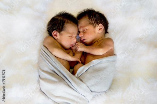 Newborn twins boy and girl sleeping together