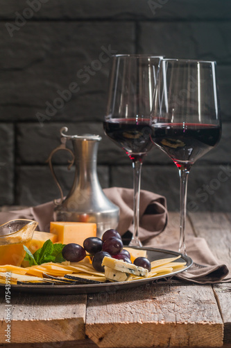 Refined still life of red wine, grapes and cheese