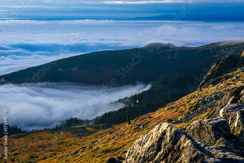 Cloud inversion from a mountain top - beautiful autumn landscape with thick blanket of rolling clouds at sunrise © photoenthusiast