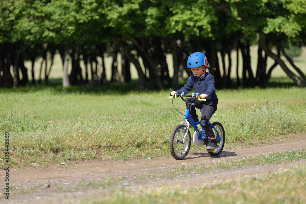 Happy kid boy of 5 years having fun in spring forest with a bicycle on beautiful fall day. Active child wearing bike helmet. Happy kid boy of 5 years having fun in spring forest with a bicycle on beautiful fall day. Active child wearing bike helmet.
