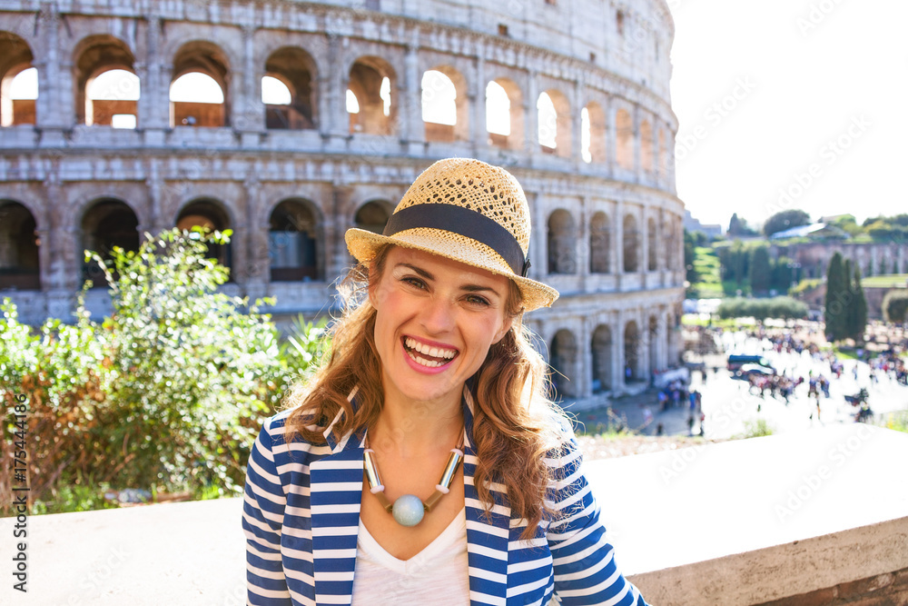 Portrait of happy young woman near Colosseum in Rome, Italy