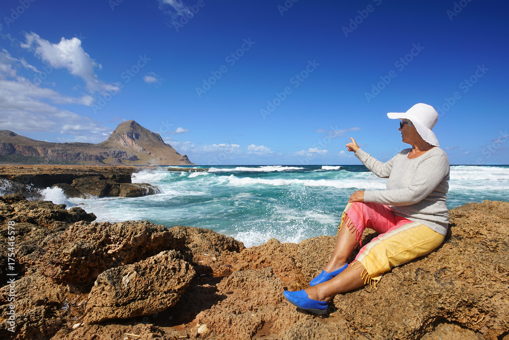 Seniorin mit Hut an der Küste von Sizilien