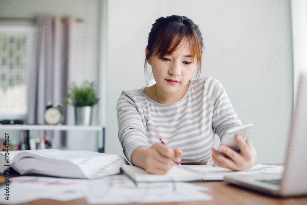 Beautiful young Asia woman working with laptop in living room Beautiful young Asia woman working with laptop in living room