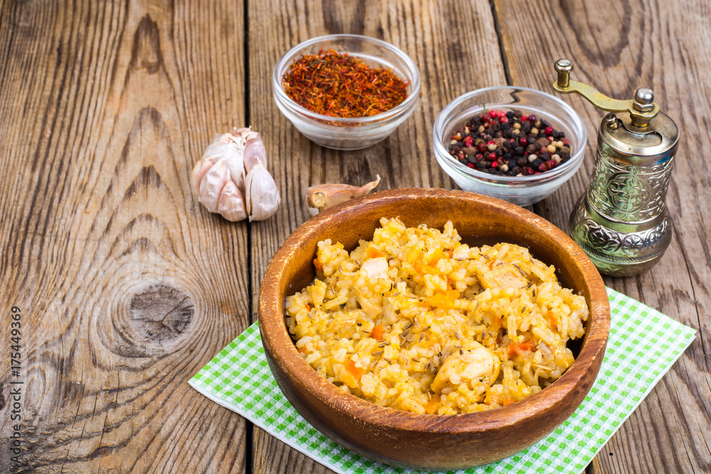 Pilaf with meat and carrots in wooden bowl on the table Pilaf with meat and carrots in wooden bowl on the table