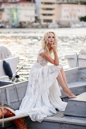 Beautiful woman in a wedding dress. A woman in a boat on a marina
