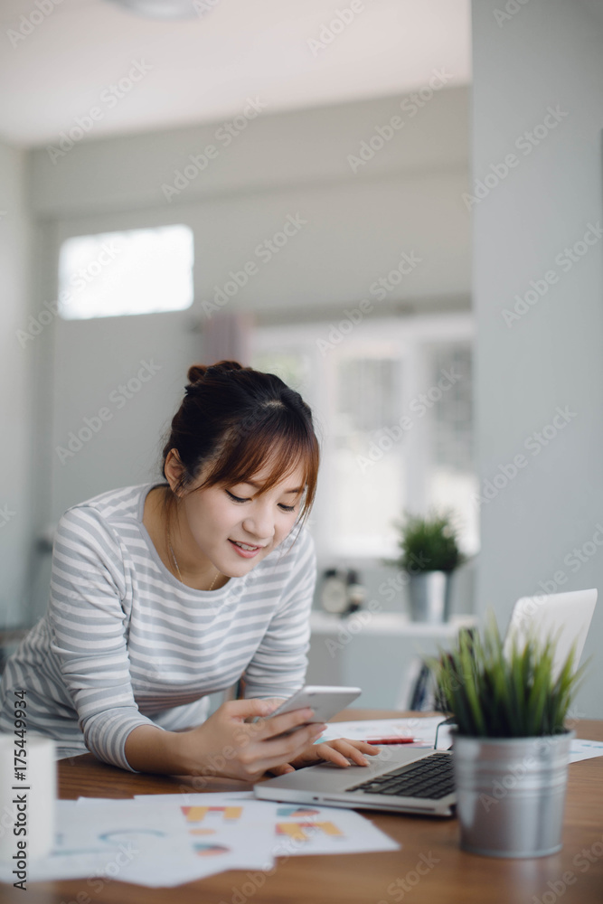 Happy casual beautiful Asia woman working on a phone in the house. Happy casual beautiful Asia woman working on a phone in the house.